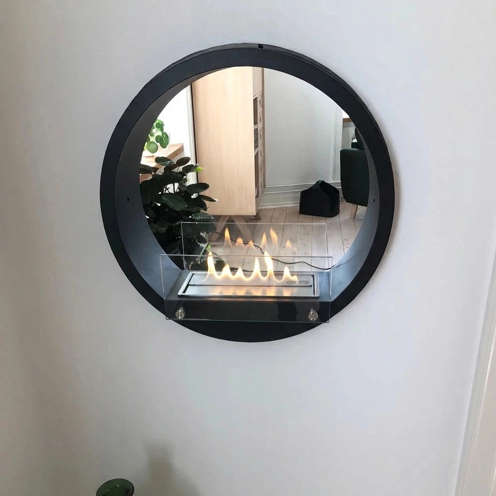 Round black built-in bioethanol fireplace mounted in a white wall, lit flame, close up