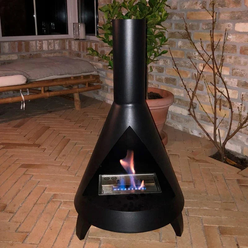 ScandiFlames Salem freestanding bioethanol fireplace lit on an evening patio beside a bench and potted plant